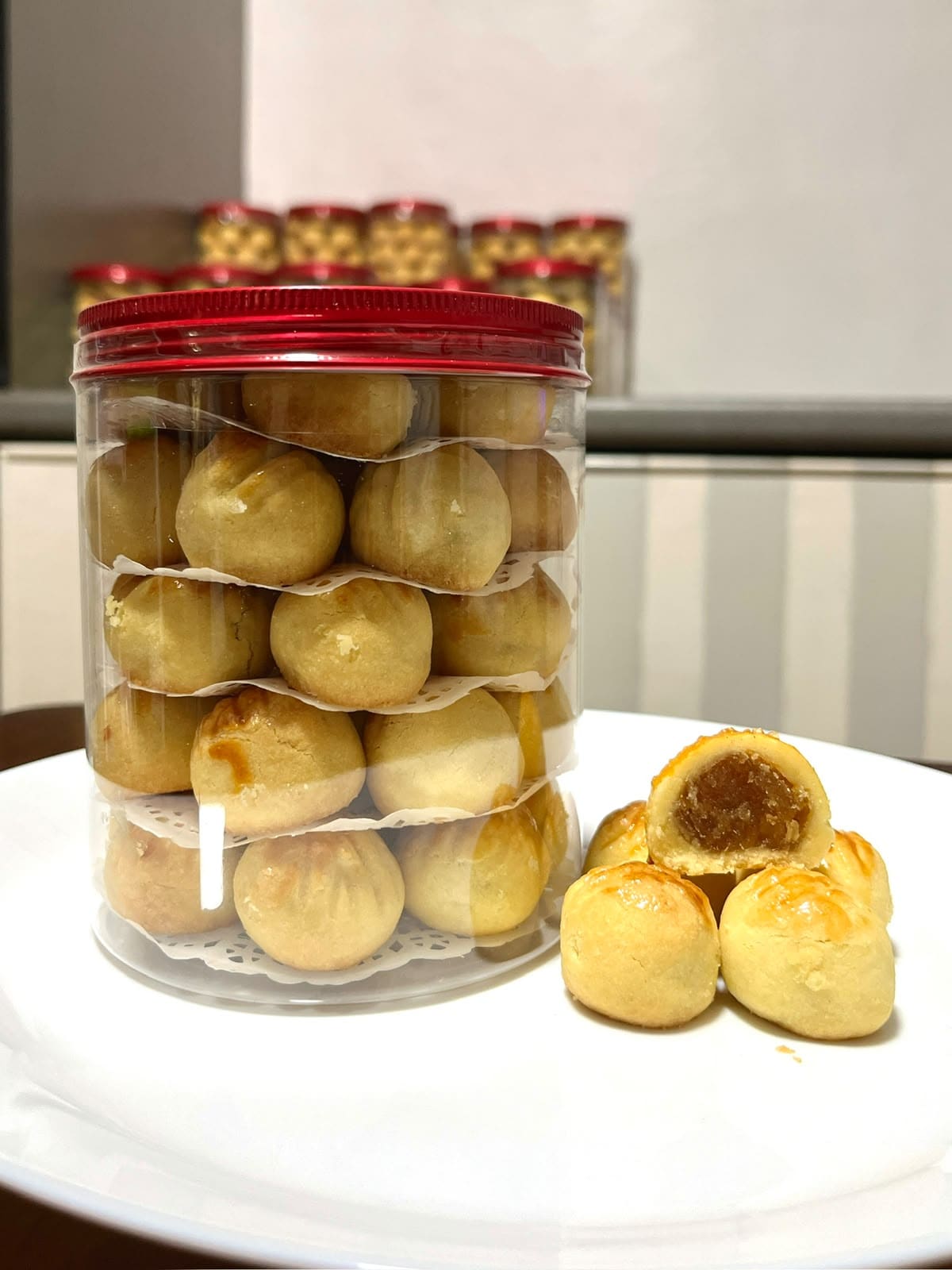 A bottle of pineapple tarts with one cut open showing the jam